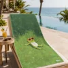 Chill Frog Plaj Havlusu, havuz kenarındaki şezlong üzerinde; yeşil zeminde kırmızı güneş gözlüklü sevimli kurbağa deseniyle sergileniyor.