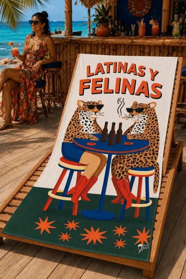 Latinas y Felinas Plaj Havlusu, güneş gözlüklü iki leopar ve “LATINAS Y FELINAS” yazılı tasarımıyla sahil barındaki ahşap şezlong üzerine serilmiş.