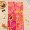 Pink Summer Plaj Havlusu, pembe ve turuncu narenciye, balık, papaya, leopar, çiçek ve denizyıldızı desenlerinin tamamını gösteren üstten görünümle kum üzerinde serili.